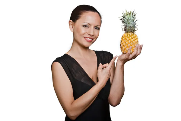 Porträt einer schönen Asiatin, die auf Ananas zeigt — Stockfoto