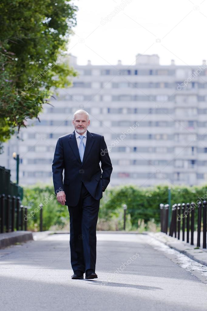 Senior businessman walking confident