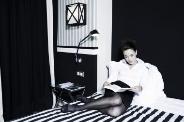 kadın bir yatak odasında bir kitap okuma