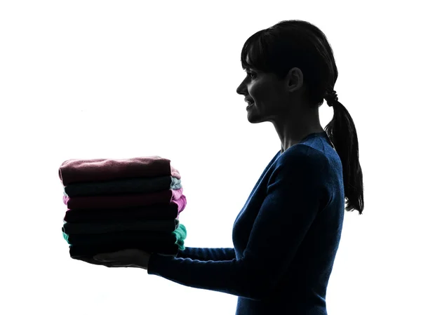 Woman maid housework holding sweater pile silhouette — Stock Photo, Image