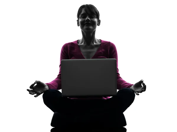 Жінка сидить в позі лотоса обчислювальний ноутбук комп'ютер силует — стокове фото