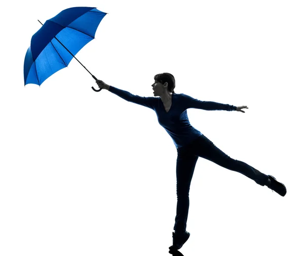 Mulher segurando guarda-chuva vento soprando silhueta — Fotografia de Stock