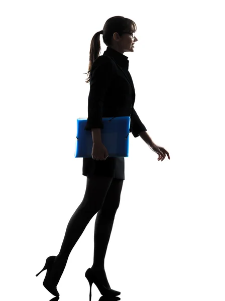 Affärskvinna som håller mappfiler promenader siluett — Stockfoto