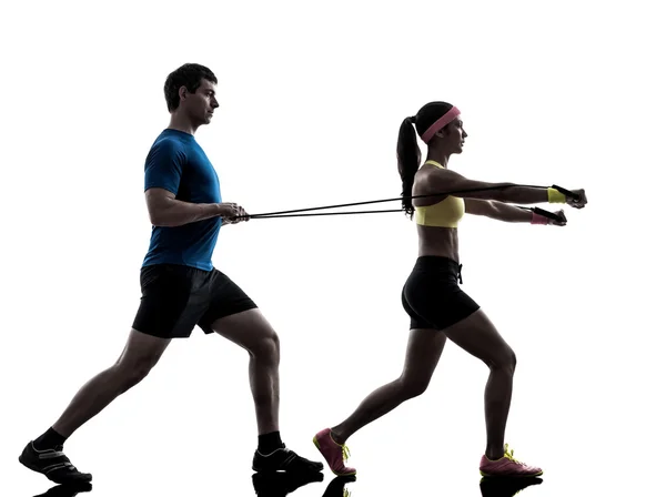 Woman exercising fitness resistance rubber band with man coach — Stock Photo, Image