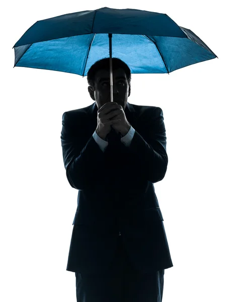 Angelägna affärsman under paraply siluett — Stockfoto