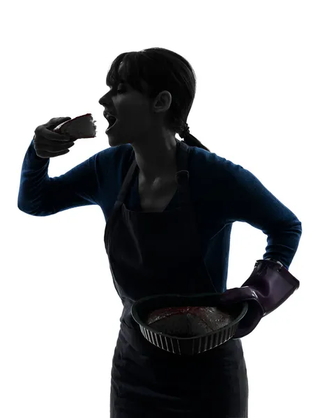 Woman greedy cooking eating chocolate cake silhouette — Stock Photo, Image