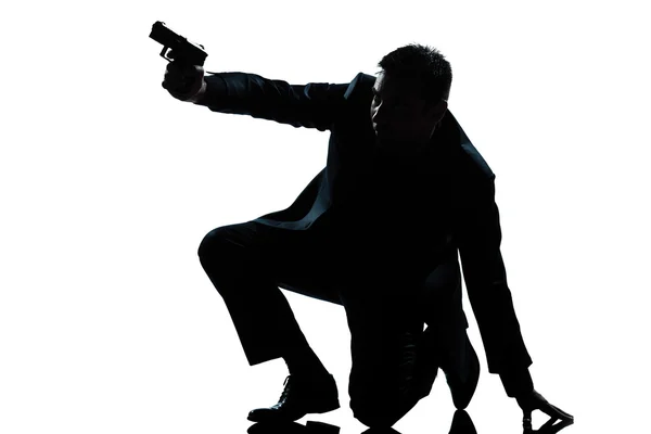 Silhouette uomo inginocchiato mirare pistola — Foto Stock