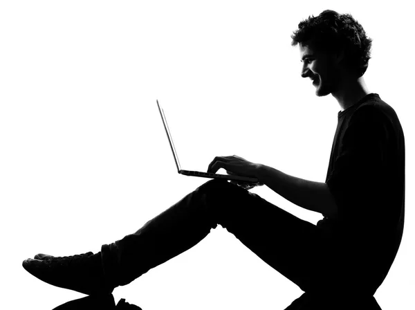 Jonge man silhouet zitten computing laptop — Stockfoto