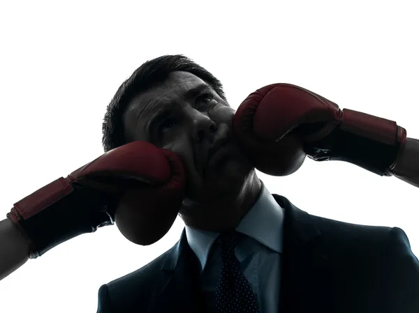 Business man punch by boxing gloves silhouette — Stock Photo, Image