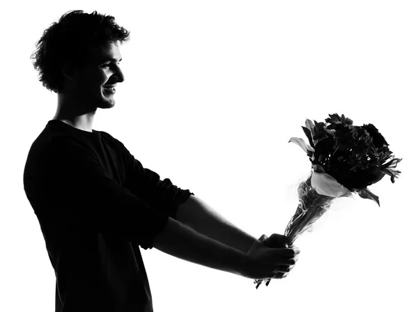 Jeune homme silhouette offrant bouquet de fleurs — Photo