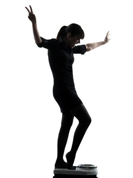 Žena stojící na váze měřítku šťastný silueta — Stock fotografie
