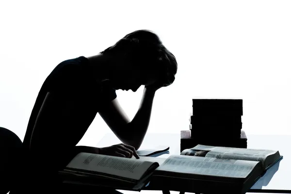 One young teenager boy girl silhouette studying reading books ti — Stock Photo, Image