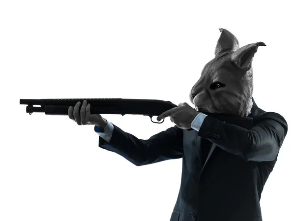 Homem com máscara de coelho caça com shotgun silhueta retrato — Fotografia de Stock
