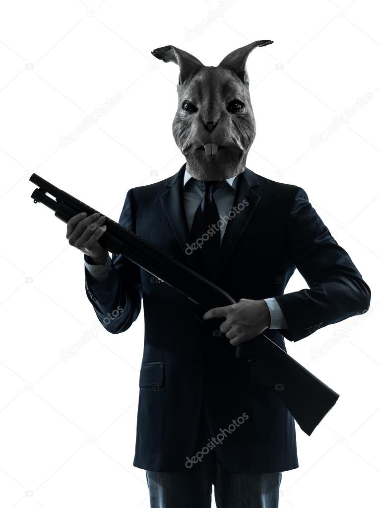Man with rabbit mask hunting with shotgun silhouette portrait Stock