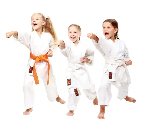 Three girls dressed in white kimono perform punch — Stock Photo, Image