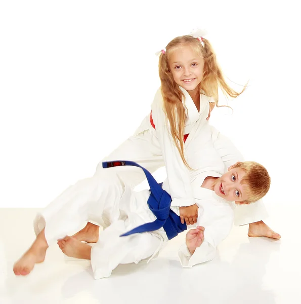 Funny kids girl in kimono boy throws — Stock Photo, Image