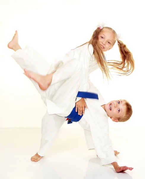 Vrolijk meisje in een kimono gooit jongen sport gooien — Stockfoto