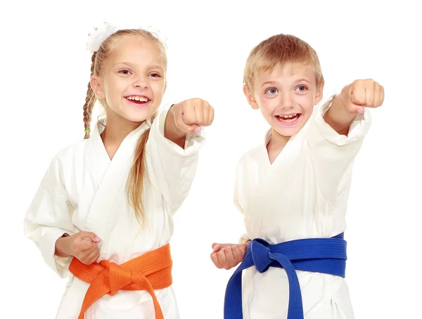 Meisje en jongen in een kimono op een witte achtergrond beat hand — Stockfoto