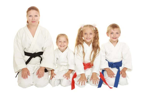 Mamma med hennes dotter och en pojke med hans syster som sitter i en karate pose ritual — Stockfoto