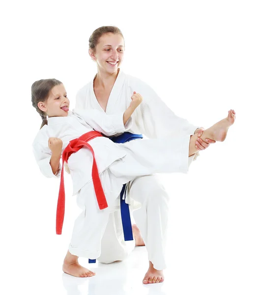 Two sisters, one teaches a sister beat kick leg — Stock Photo, Image