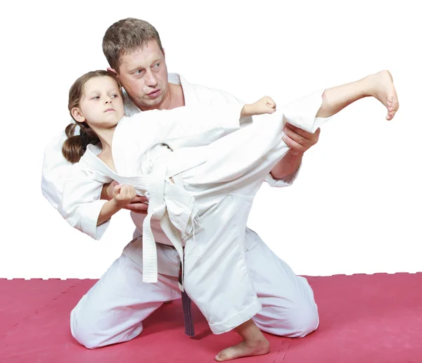 Папа учит свою дочь, одетую в кимоно, пинаться ногами. — стоковое фото