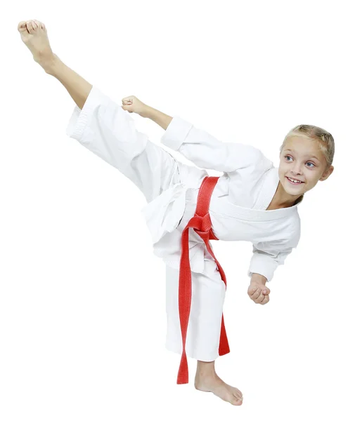 Een klein meisje in een witte kimono hits roundhouse kick geïsoleerd achtergrond — Stockfoto