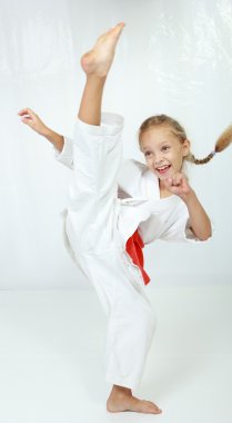 Kız atlet bir kimono içinde dairesel bir tekme bacak gerçekleştirir
