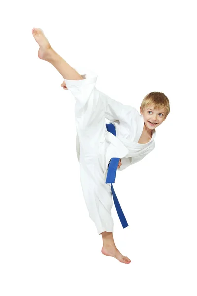 Boy athlete in a kimono performs a kick leg circular insulated — Stock Photo, Image