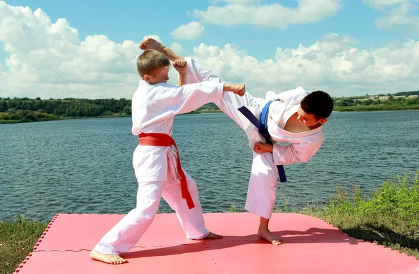 Los atletas niños realizan ejercicios pareados karate — Foto de Stock
