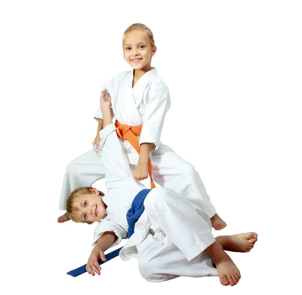 Cheerful kids athletes in kimono doing throws — Stock Photo, Image