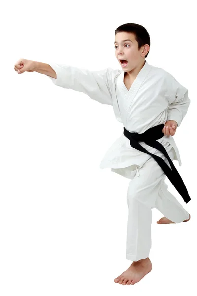 I rack av karate pojke med ett svart bälte slår en punch arm — Stockfoto