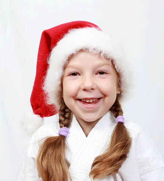 A menina de quatro anos com um boné na cabeça Papai Noel — Fotografia de Stock