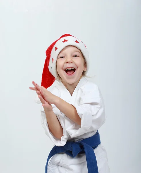Chica atleta alegre en un kimono y gorro de Santa Claus — Foto de Stock