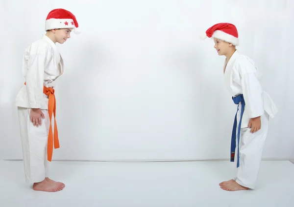 Sportifs en casquettes Père Noël fait un arc rituel — Photo