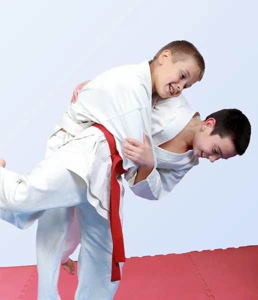 Twee jongens met witte en rode gordel uitvoeren gooien judo — Stockfoto