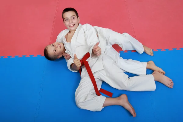 Two young athlete with a red and white belt show finger super — Stockfoto