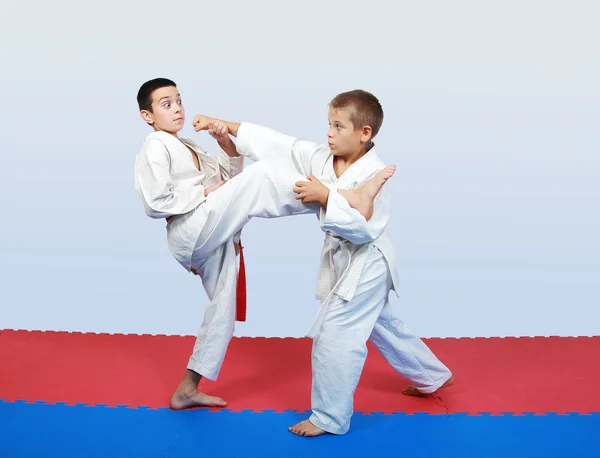 Boys with a red and white belt do paired exercises karate — Stok fotoğraf