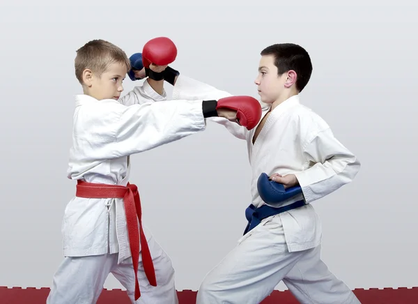 With blue and red belt boys train paired exercises karate — Stock Photo, Image