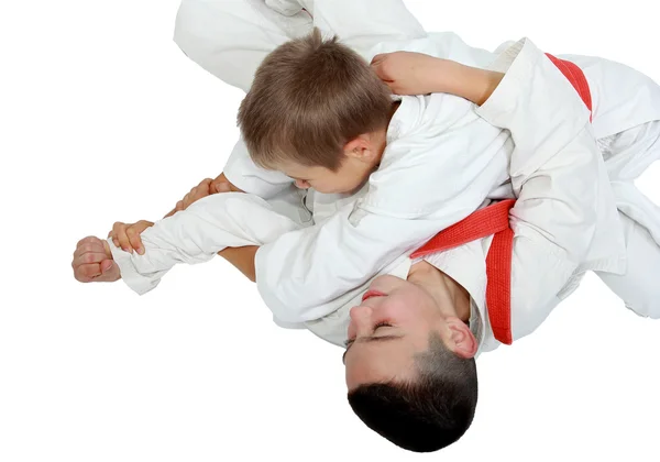 Athlete on a white background with a red belt makes a reception — Stock Photo, Image