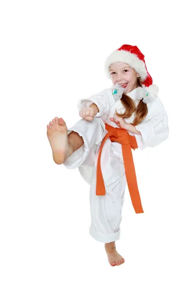 Sur un fond blanc petite fille dans un kimono frappe une jambe de pied isolé — Photo