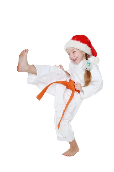 In the kimono and cap Santa Claus little girl beats a kick leg — Stock Photo, Image