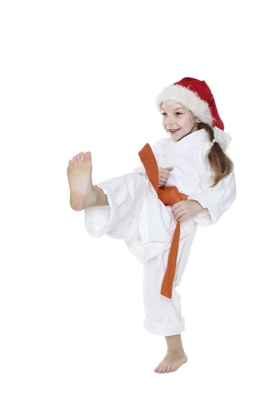 En una gorra Santa Claus pequeño deportista golpeó una pierna de patada — Foto de Stock