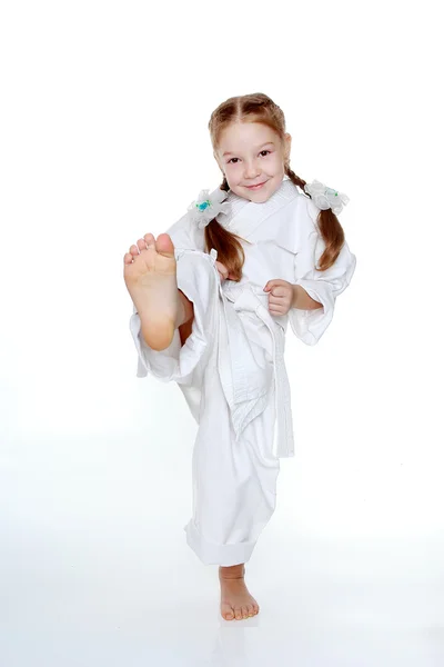 Sportlerin im weißen Kimono schlägt ein Schlagbein — Stockfoto