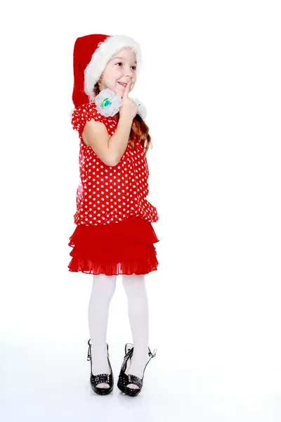 Fröhliches Mädchen in gepunktetem Kleid und Hut aus Weihnachtsmann — Stockfoto