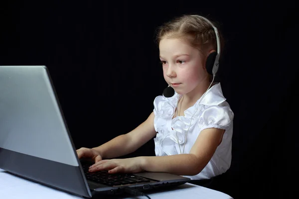 Niña concentrada sentada frente a la computadora — Foto de Stock