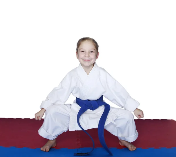 In rack is stand a little girl with a blue belt — Stock Photo, Image