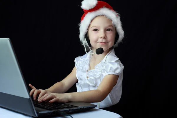 Kleines Mädchen mit Kopfhörern am Computer — Stockfoto