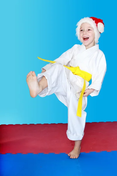 Com o cinto amarelo uma menina bate uma perna de chute — Fotografia de Stock