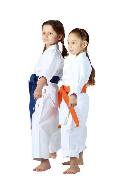 Girls athletes with orange and blue belt stand in rack — Stock Photo, Image