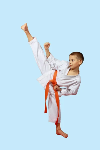 Small sportsman in a kimono performs a high blow foot — Stock Photo, Image